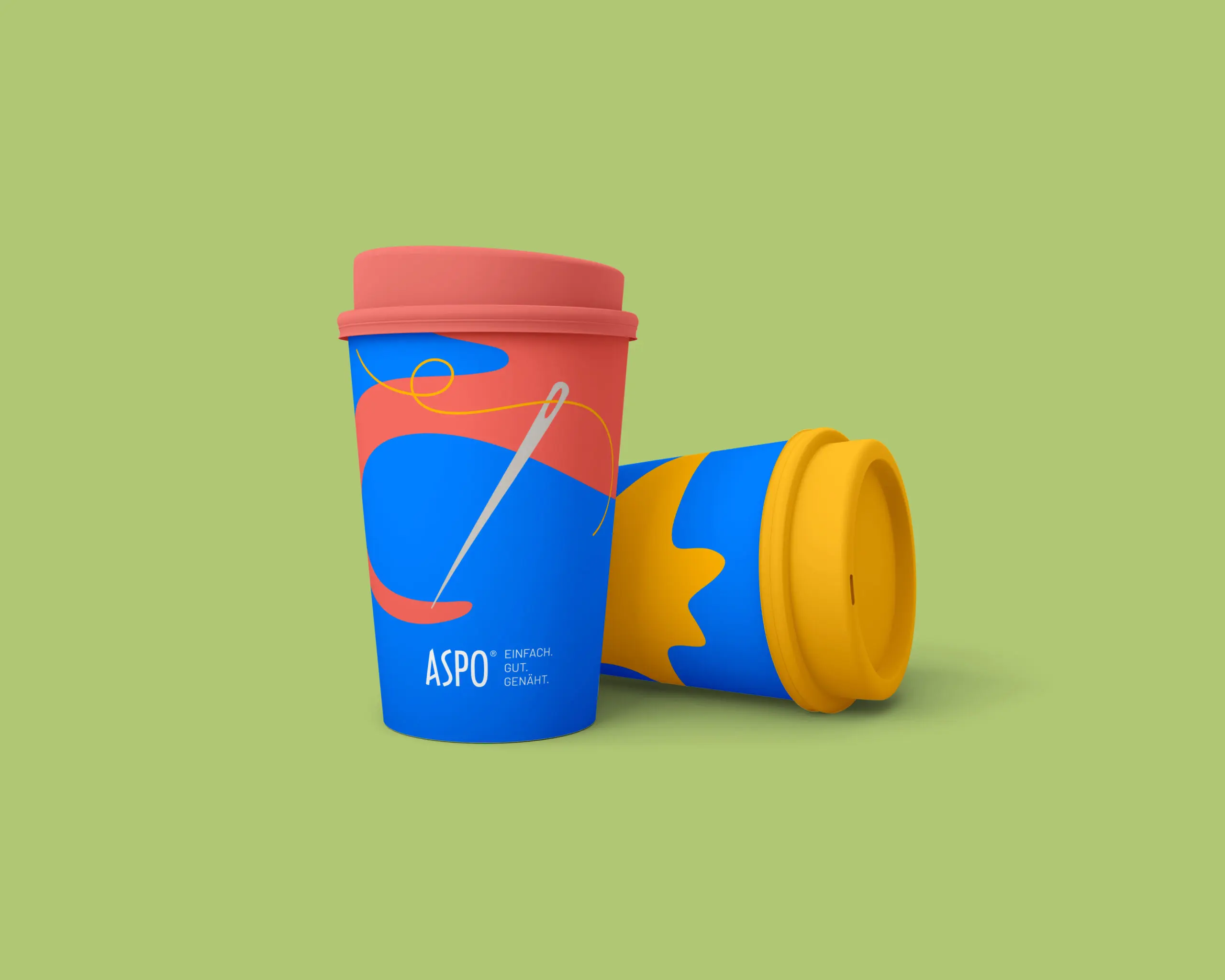 Auf einem hellgrünen Hintergrund stehen zwei bunte Mehrwegbecher mit abstrakten Mustern in Blau, Rot und Gelb. Ein Becher steht aufrecht mit einem roten Deckel, während der andere Becher auf der Seite liegt und einen gelben Deckel hat.